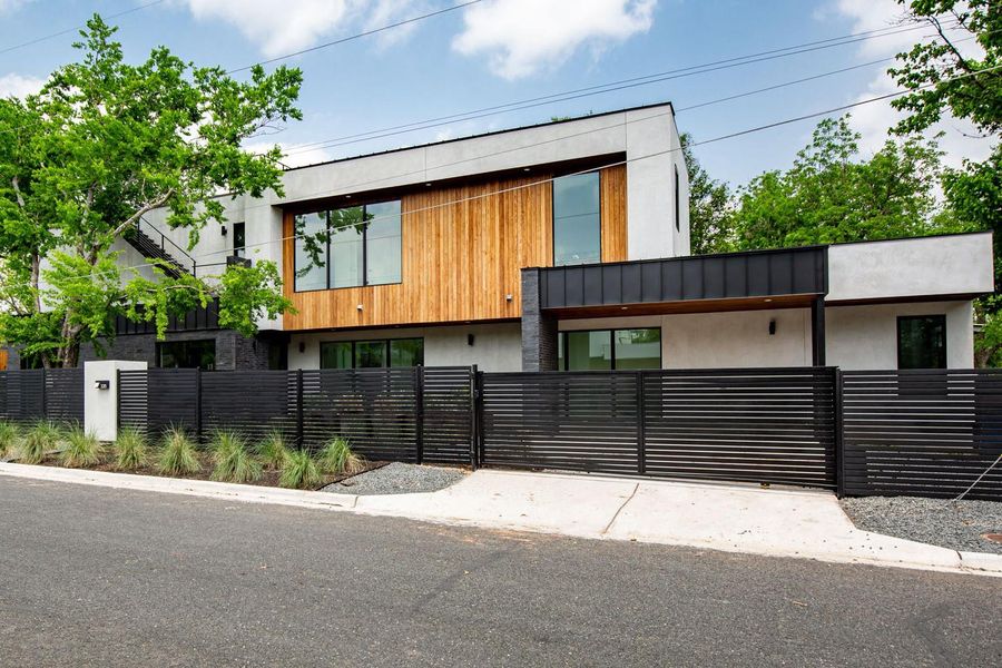 Contemporary home featuring a fenced front yard and a gate