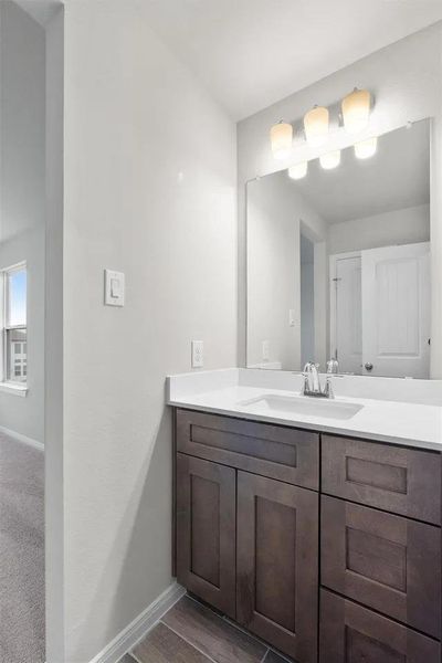 A well-appointed vanity with dark wood cabinetry and a pristine white countertop, perfect for daily routines.