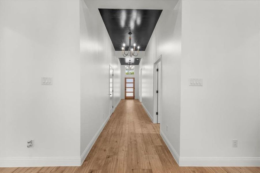 Hall featuring light wood-type flooring and a chandelier