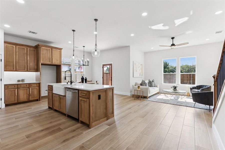 Kitchen featuring a kitchen island with sink, sink, light hardwood / wood-style floors, and dishwasher