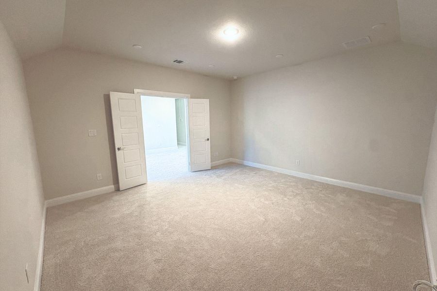 Spacious room featuring neutral carpeting, light-toned walls, and white trim