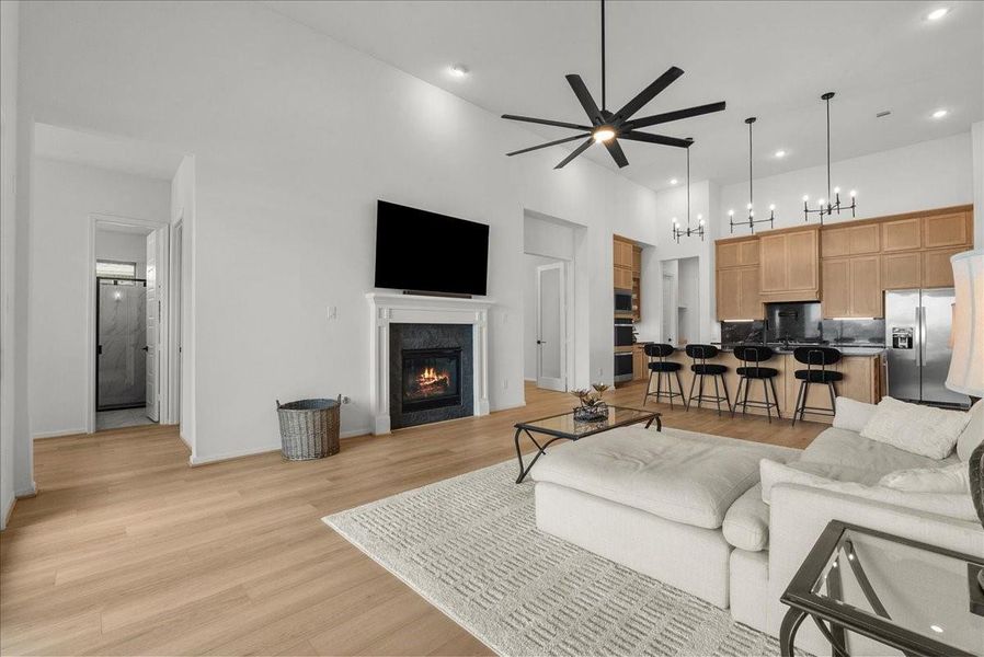 Living room showcases soaring ceilings, a cozy fireplace, and breathtaking water views.