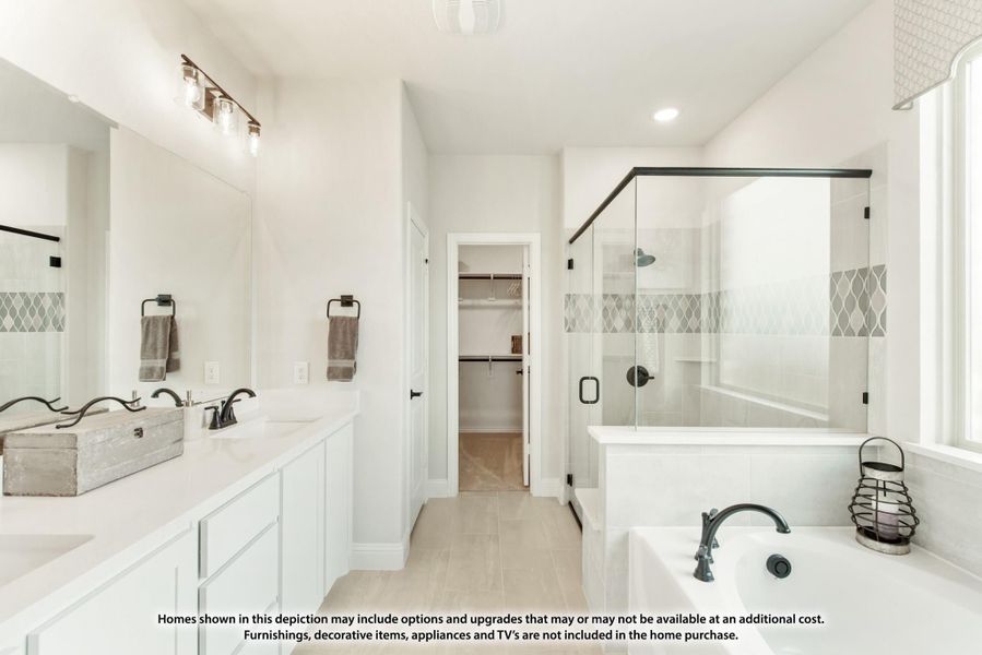 Master bathroom with double vanity, glass walk-in shower, soaking tub, and walk-in closet entry