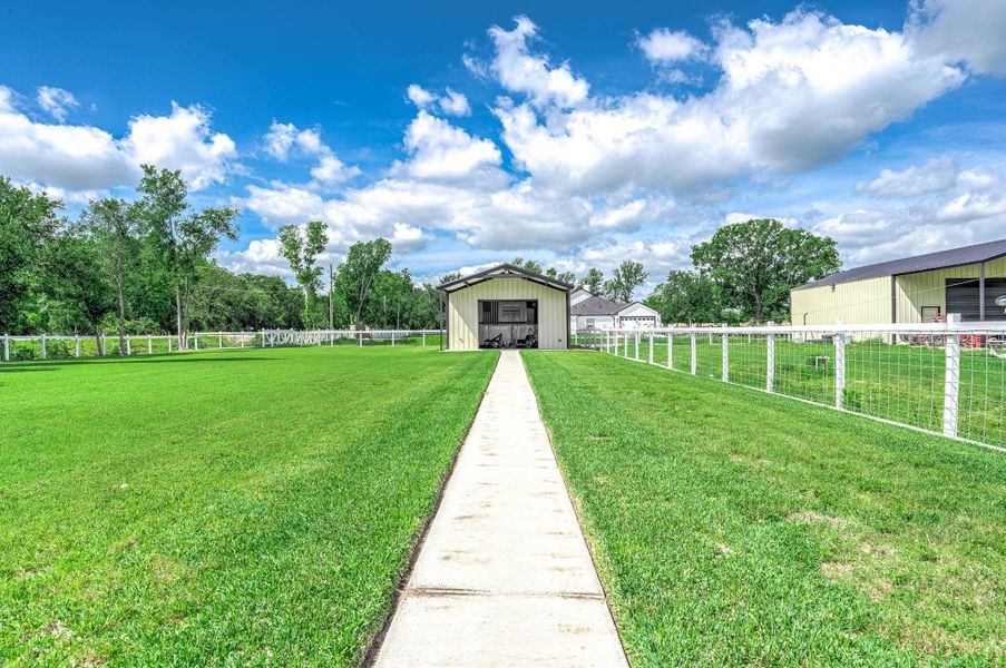 This versatile outbuilding is currently being utilized as a climate-controlled gym space, offering endless potential for a home gym, workshop, studio, storage, or hobby area. The surrounding outdoor space and functional layout add even more flexibility to the property.