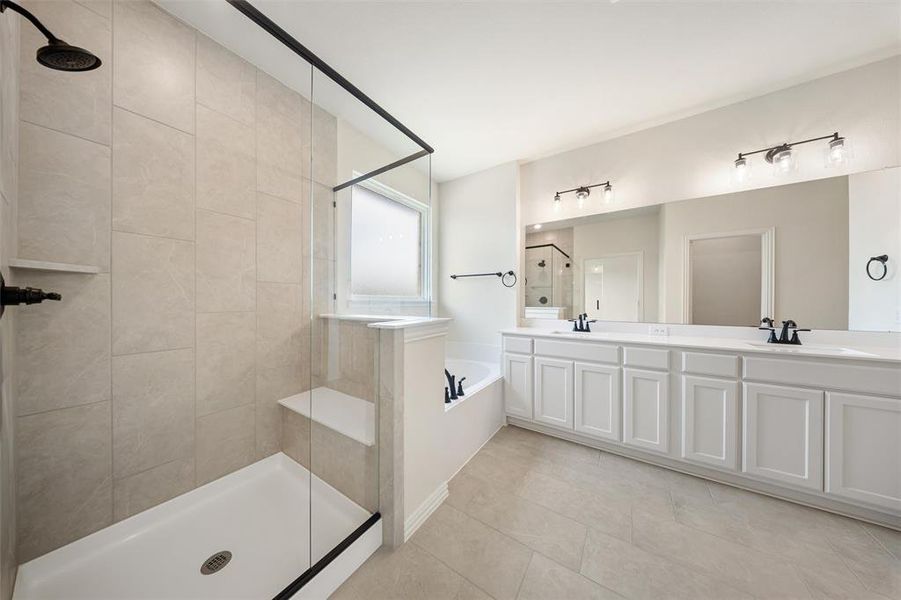 Bathroom featuring tiled shower, a bath, double vanity, and tile patterned flooring