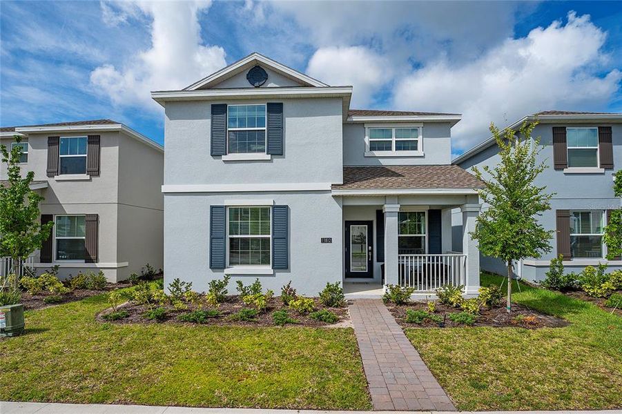 Front exterior of a new home in Storey Park: Innovation Manor Collection, Orlando, FL, highlighting curb appeal (Image 1).