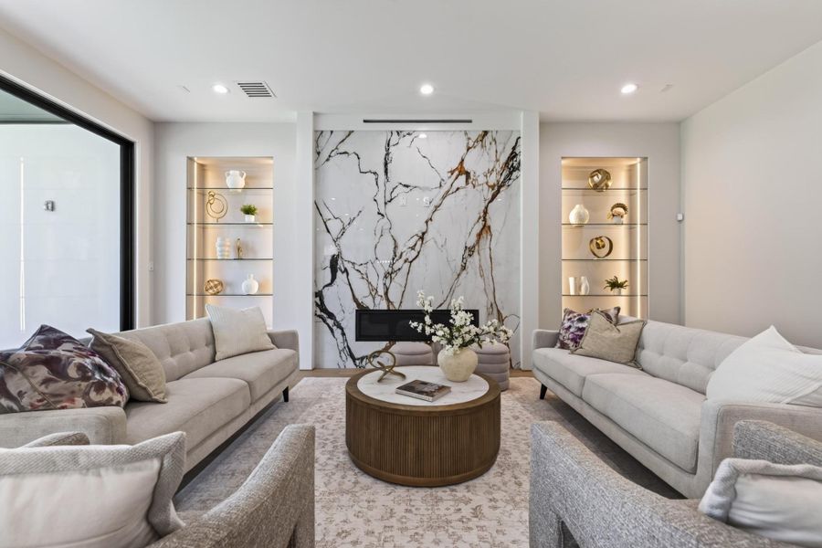 Bright open-concept living area with designer lighting, neutral palette, and seamless flow to the kitchen.