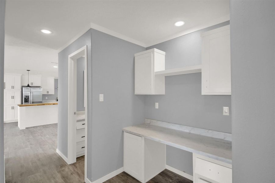 Built-in cabinetry and a stone-look countertop create a highly functional home workspace.