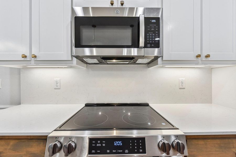 Modern kitchen with sleek stainless steel appliances and quartz backsplash. Modern kitchen with sleek stainless steel appliances and quartz backsplash.