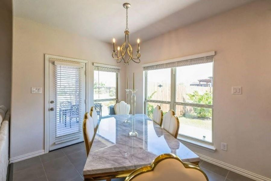 Tiled dining space featuring a notable chandelier