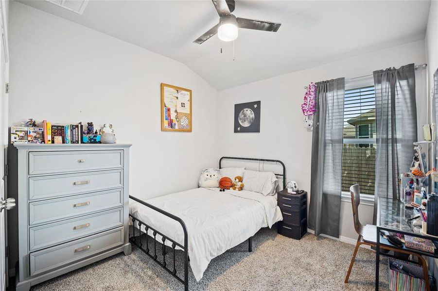 Bedroom featuring light colored carpet, lofted ceiling, and ceiling fan