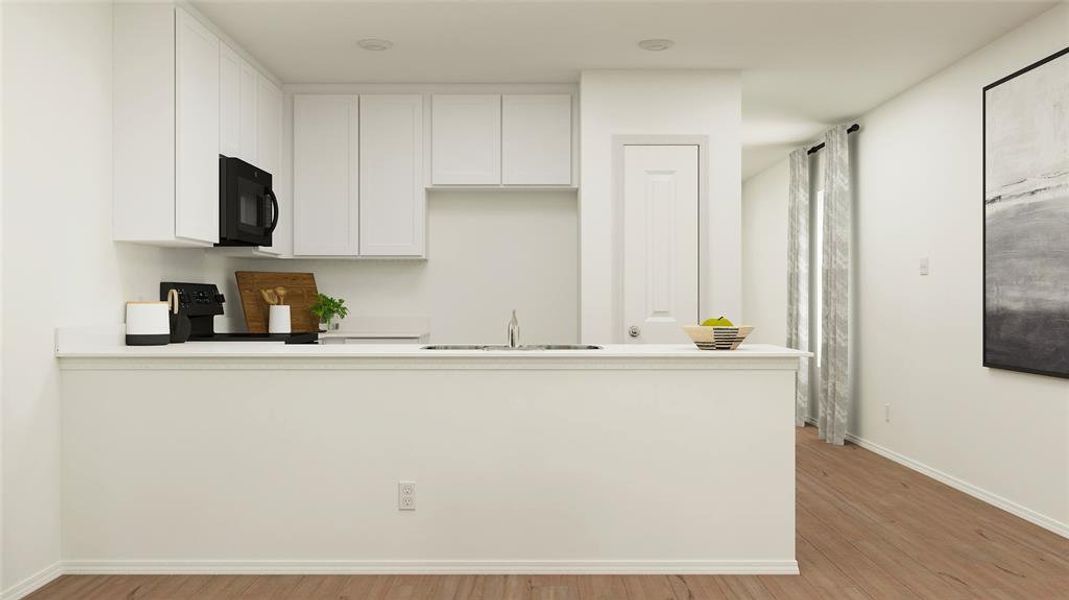 Kitchen with white cabinets, sink, kitchen peninsula, black appliances, and light wood-type flooring