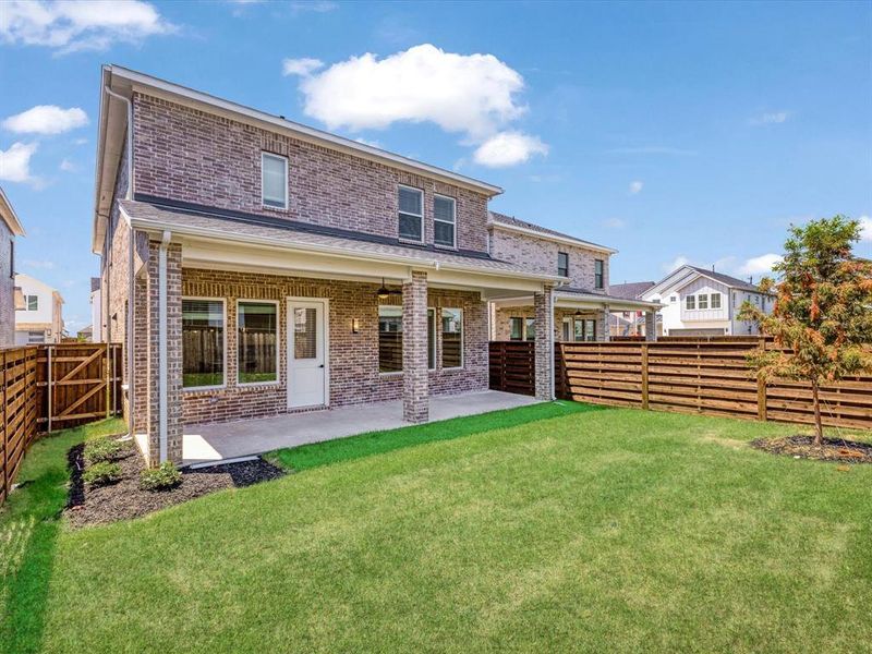 Rear view of house with brick siding, a patio, and a fenced backyard