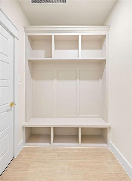 Mudroom with baseboards, visible vents, and wood finish floors