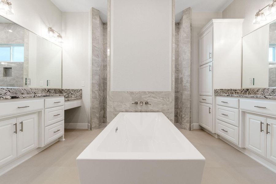 Full bathroom with healthy amount of natural light, a soaking tub, vanity, and tile walls