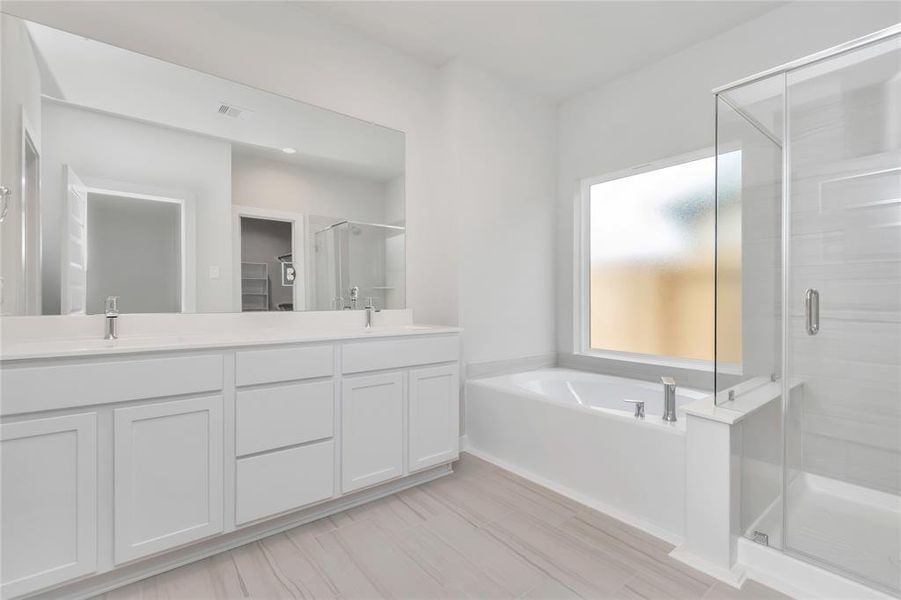 Immerse yourself in a luxurious retreat within the confines of your main bathroom. Sample photo of completed home with similar floor plan. As-built interior colors and selections may vary