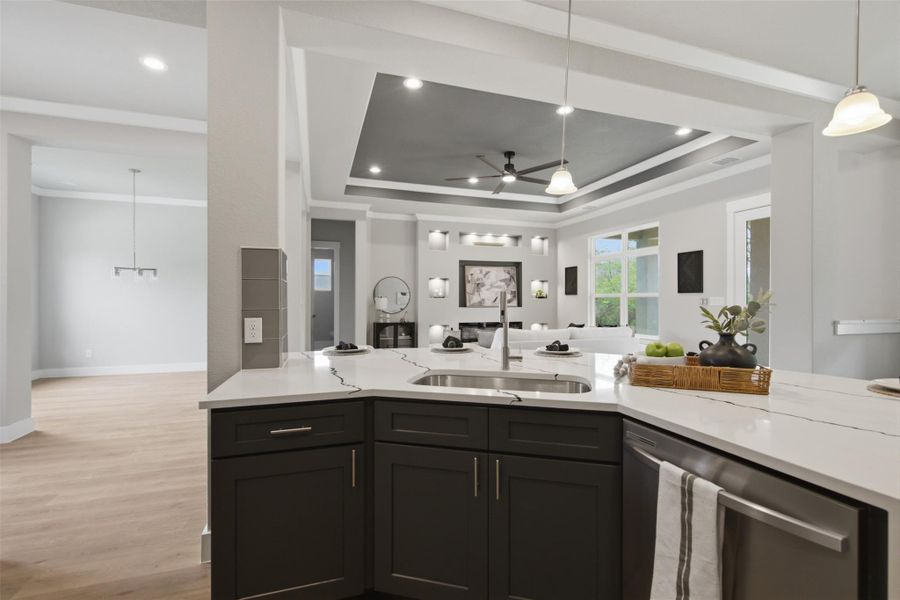 A well-appointed kitchen island with a sink offers ample counter space and a clear sightline to the inviting living area. A well-appointed kitchen island with a sink offers ample counter space and a clear sightline to the inviting living area.