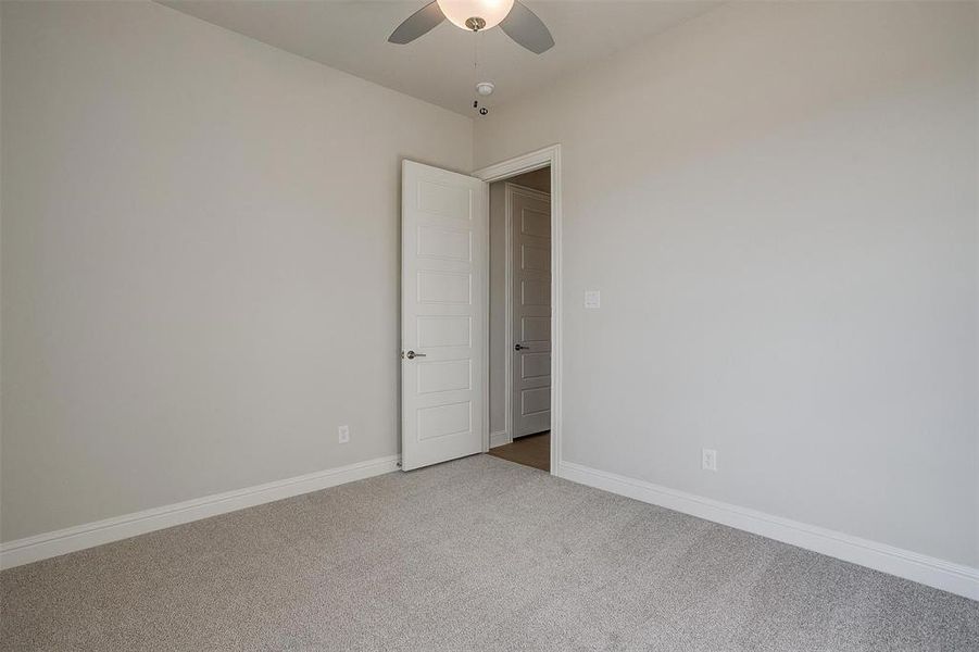 Carpeted spare room with ceiling fan