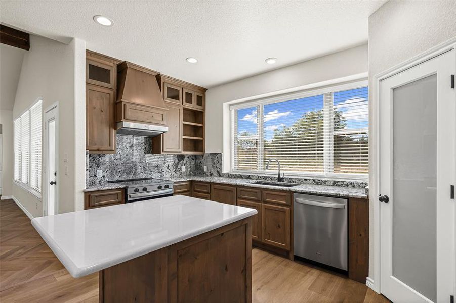 Kitchen with backsplash, appliances with stainless steel finishes, a center island, plenty of natural light, and recessed lighting
