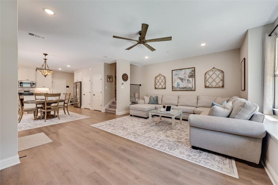 Open-concept living space featuring upgraded Pergo water tight laminate wood look flooring, recessed lighting, and a high end modern ceiling fan Open-concept living space featuring upgraded Pergo water tight laminate wood look flooring, recessed lighting, and a high end modern ceiling fan