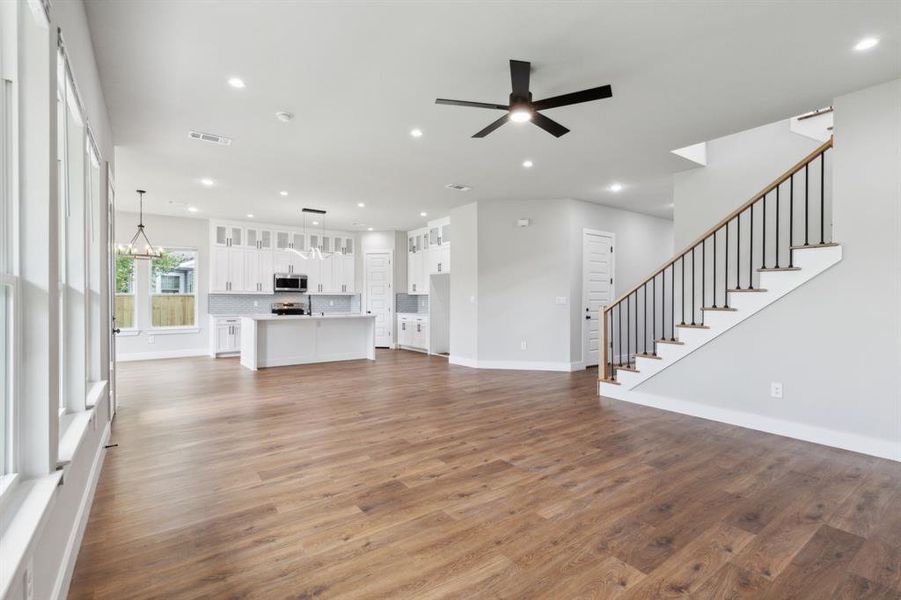 Unfurnished living room featuring ceiling fan and wood-type flooring