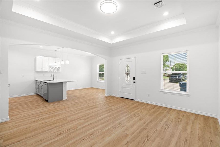 Foyer entrance featuring healthy amount of natural light, ornamental molding, light wood-type flooring, arched walkways, and recessed lighting Foyer entrance featuring healthy amount of natural light, ornamental molding, light wood-type flooring, arched walkways, and recessed lighting
