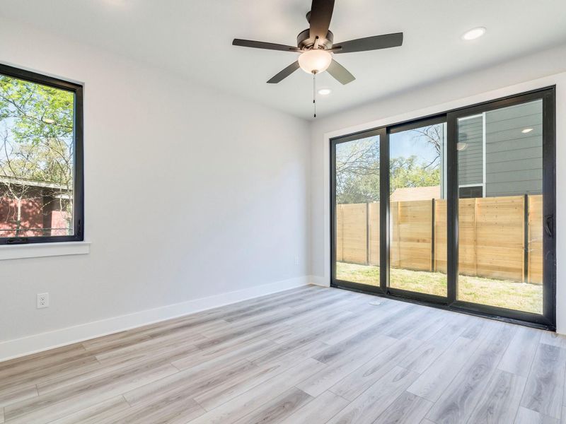 Primary bedroom (main floor) with large sliding door to the backyard.