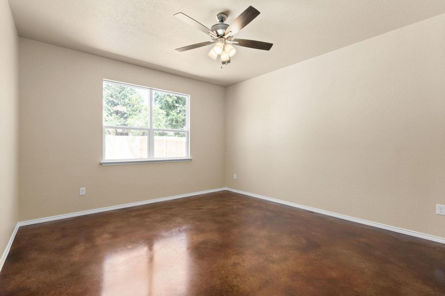 Spare room featuring concrete flooring, ceiling fan, and a textured ceiling