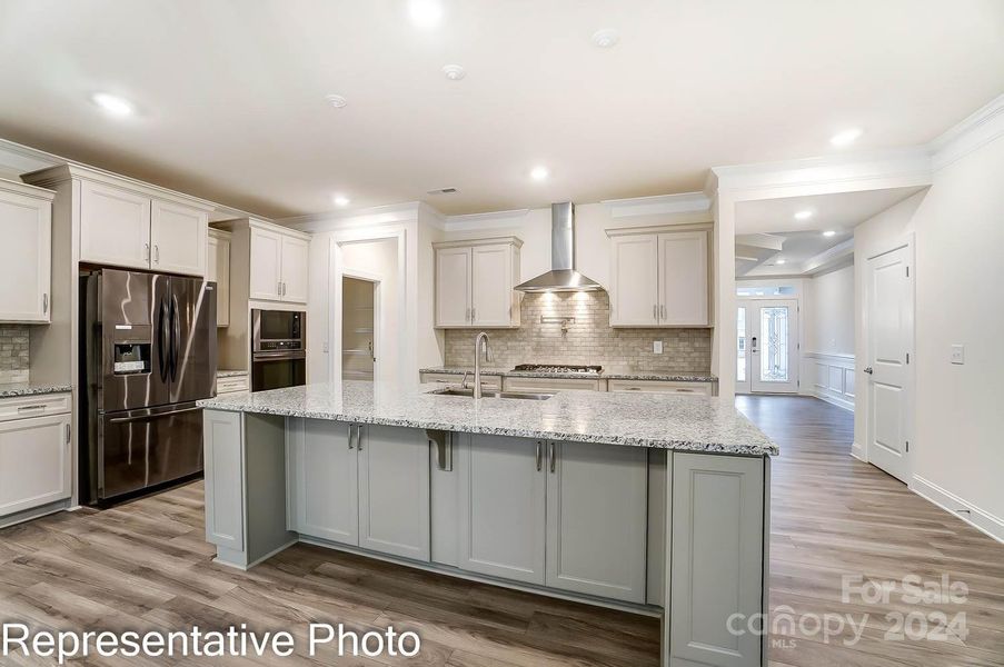 Kitchen features white cabinets with contrasting grey island