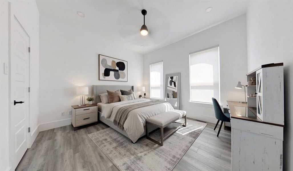 Spacious room featuring wood-finish flooring, two large windows with roller shades, recessed lighting, and a contemporary ceiling fan Spacious room featuring wood-finish flooring, two large windows with roller shades, recessed lighting, and a contemporary ceiling fan