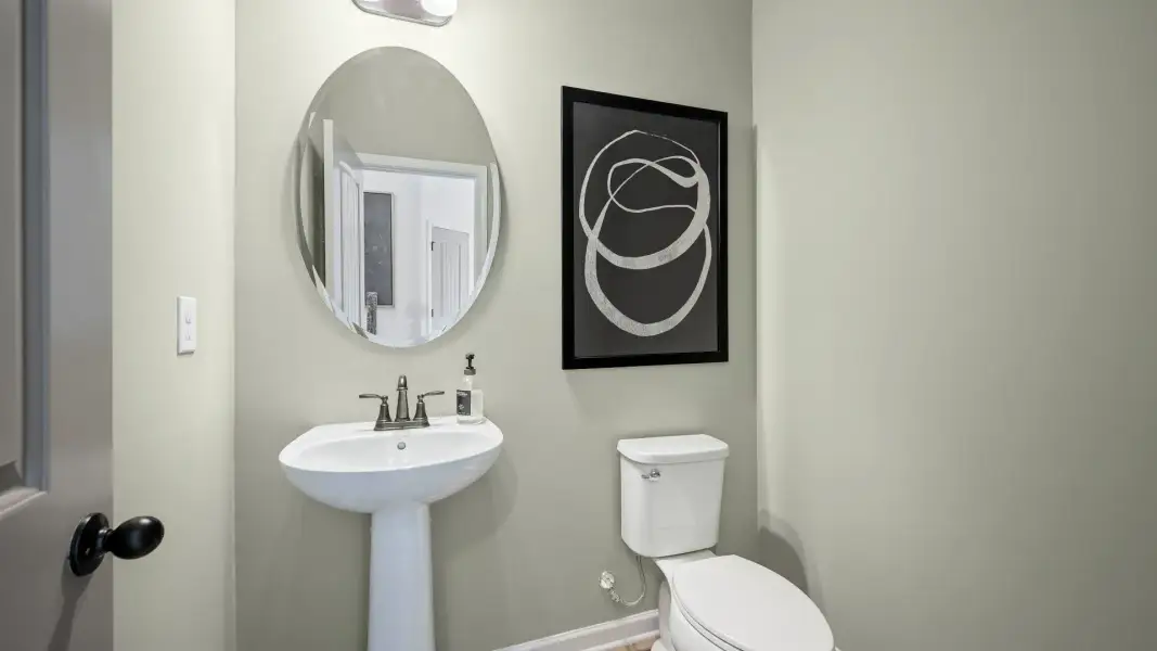 Elegant half bath with pedestal sink and modern fixtures in Langley Overlook townhome in Loganville, Georgia.