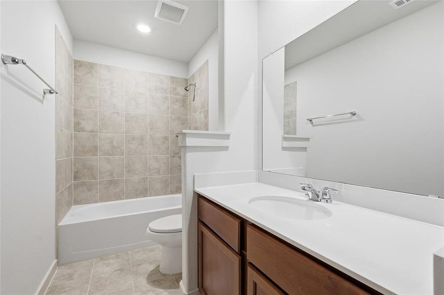 Full bath with shower / bath combination, vanity, and light tile patterned floors Full bath with shower / bath combination, vanity, and light tile patterned floors