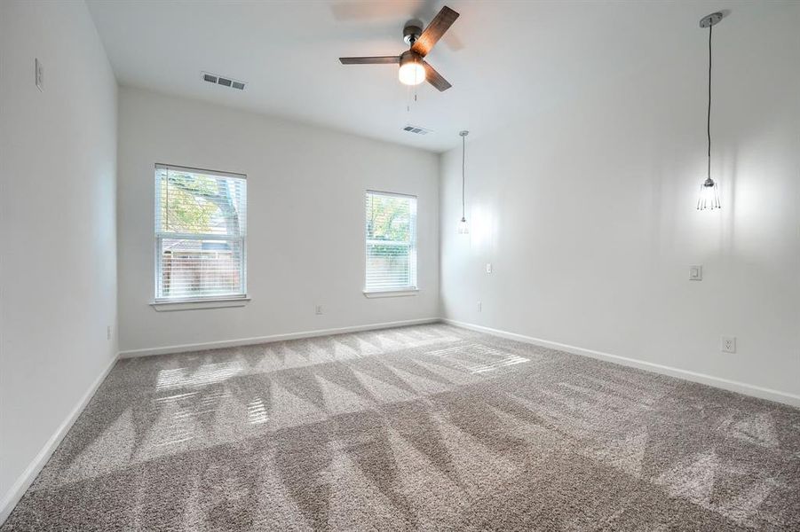 Unfurnished room featuring carpet and a ceiling fan