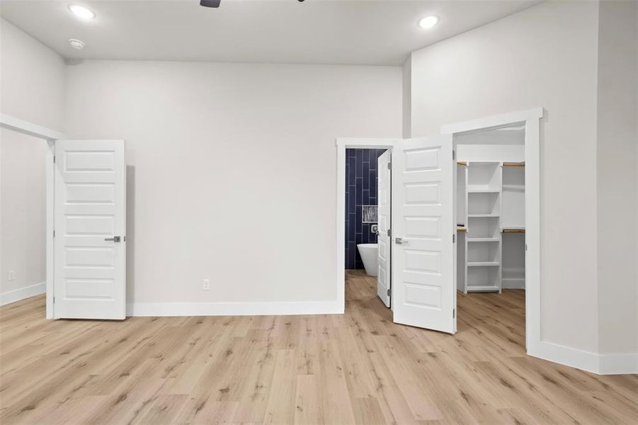 Unfurnished bedroom with light hardwood / wood-style flooring, a spacious closet, and a closet