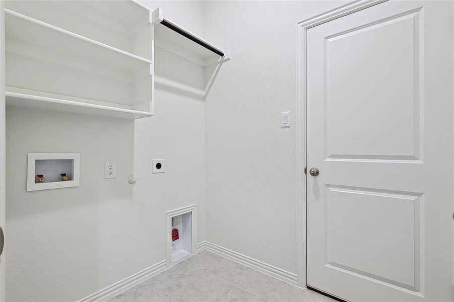 Laundry room featuring light tile floors, hookup for a washing machine, electric dryer hookup, and hookup for a gas dryer