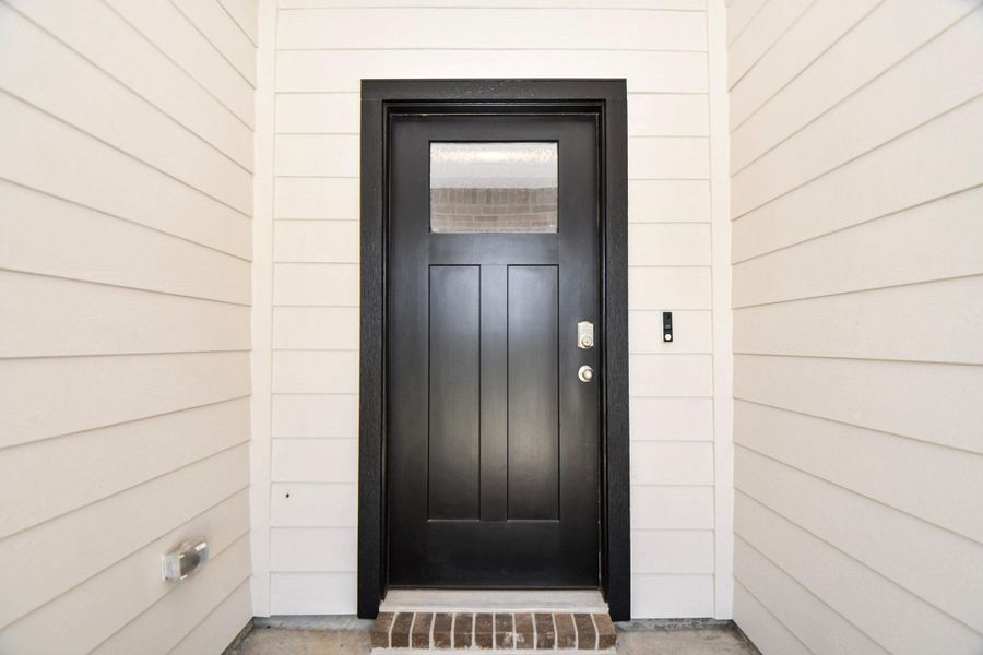 This sleek black door welcomes you into this modern, clean home.