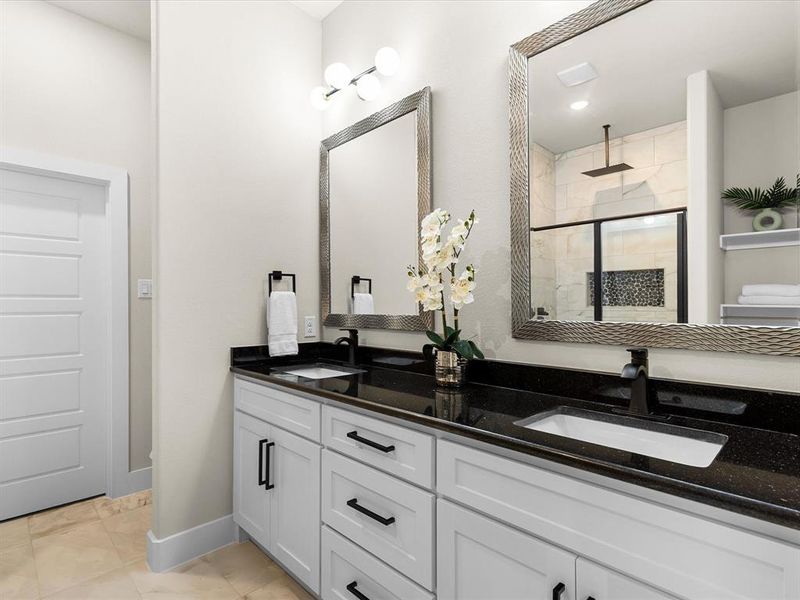 Bathroom featuring double vanity and a stall shower