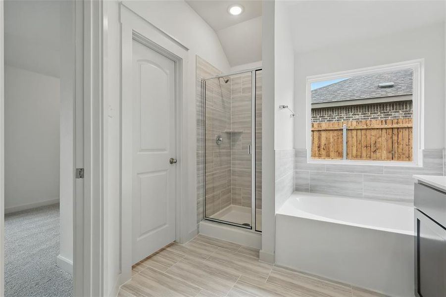 Bathroom with a stall shower, vanity, and a garden tub Bathroom with a stall shower, vanity, and a garden tub