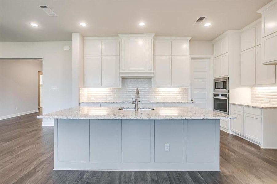 Kitchen with dark hardwood / wood-style floors, stainless steel appliances, backsplash, and sink