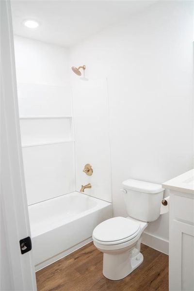 Full bathroom featuring vanity, hardwood / wood-style floors, shower / bathing tub combination, and toilet