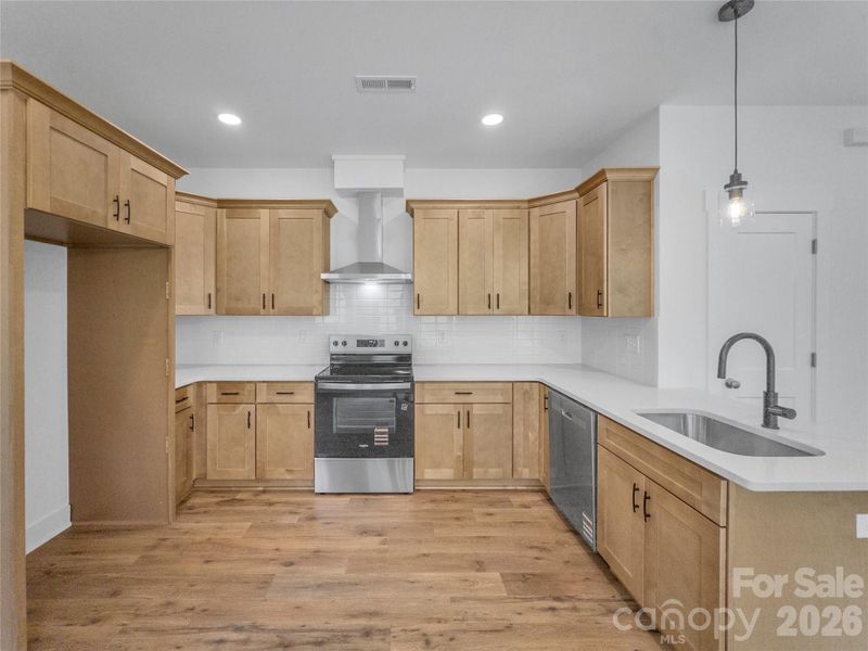 Kitchen with soft close cabinetry, quartz counters, and stainless steel appliances Kitchen with soft close cabinetry, quartz counters, and stainless steel appliances