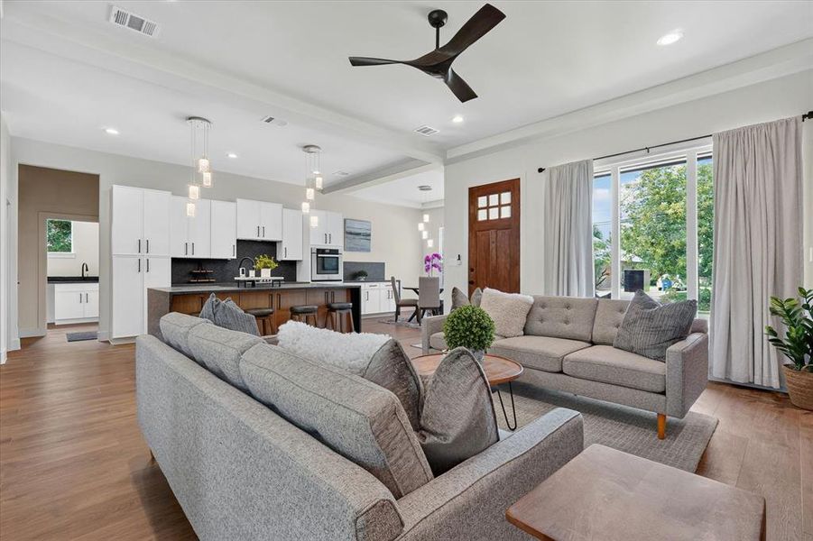 Open-concept living area featuring wood-finish flooring, recessed lighting, and a modern ceiling fan