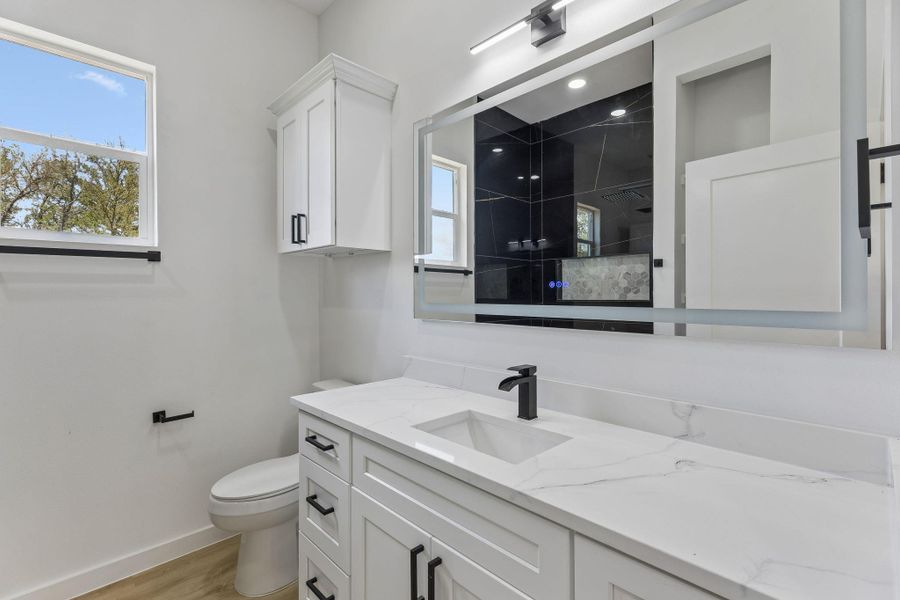 Clean lines and stone counters highlight this modern bathroom space.