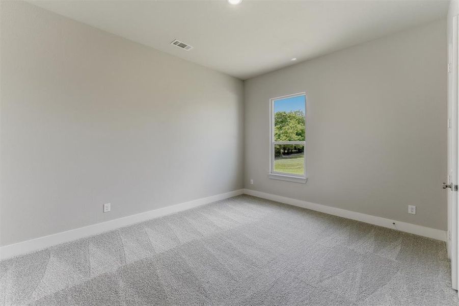 Neutral wall color, patterned carpet flooring, recessed lighting, and a single pane window with white trim