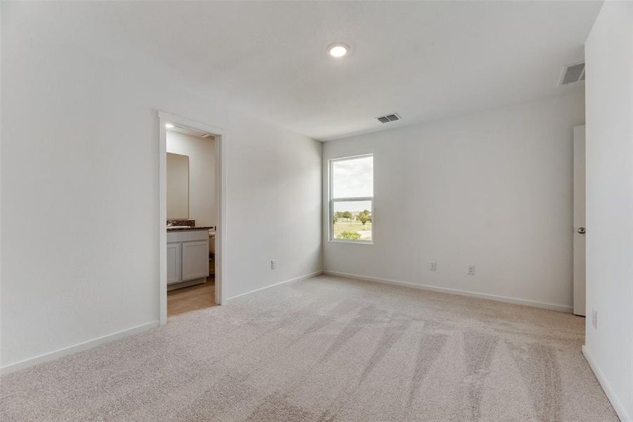 Unfurnished bedroom featuring light carpet and ensuite bathroom