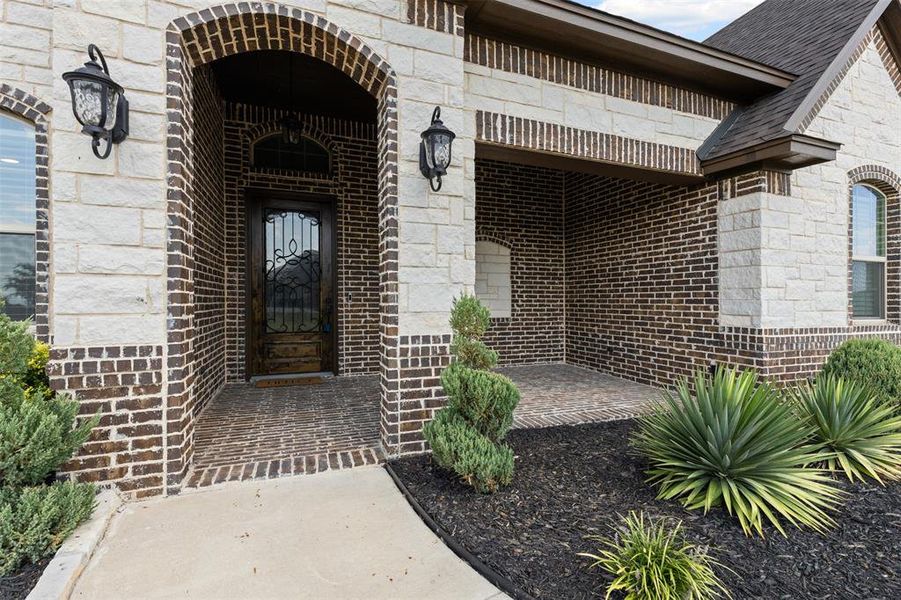 View of exterior entry with brick siding and stone siding View of exterior entry with brick siding and stone siding