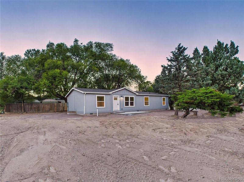 Level 0.23-acre lot with mature trees around the perimeter offering shade and privacy.