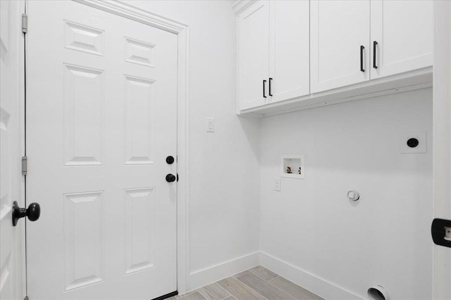 Laundry room featuring hookup for a washing machine, cabinet space, light wood-style floors, electric dryer hookup, and baseboards