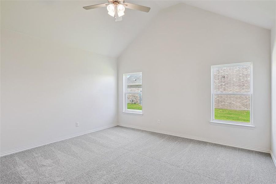 Spare room featuring light colored carpet, high vaulted ceiling, and ceiling fan