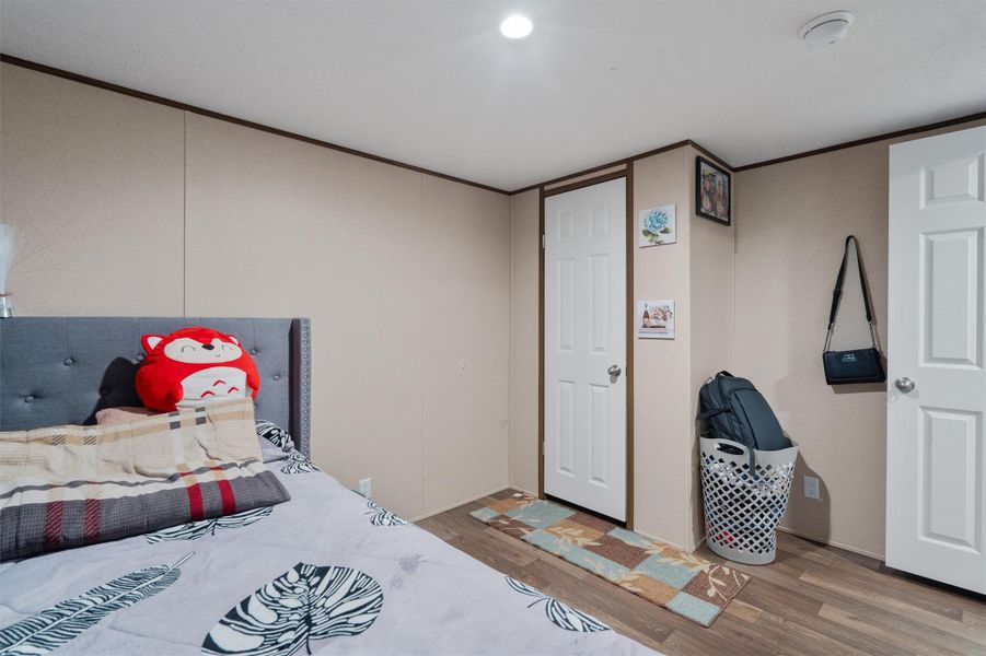Smooth wood-look flooring and clean drywall finishes frame this quiet sleeping space.